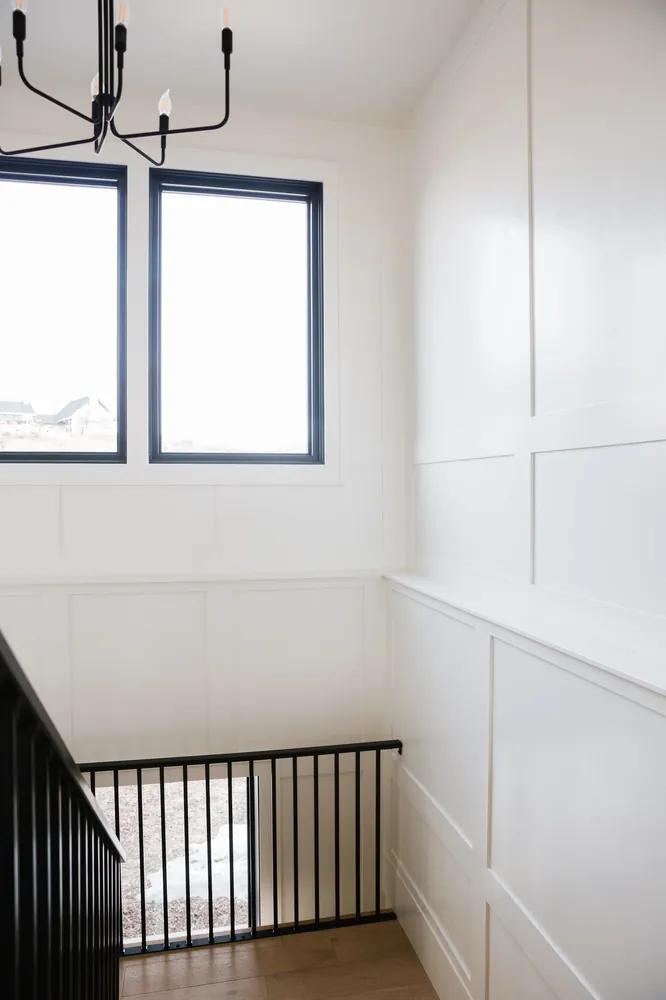Black stair railing with paneled wall