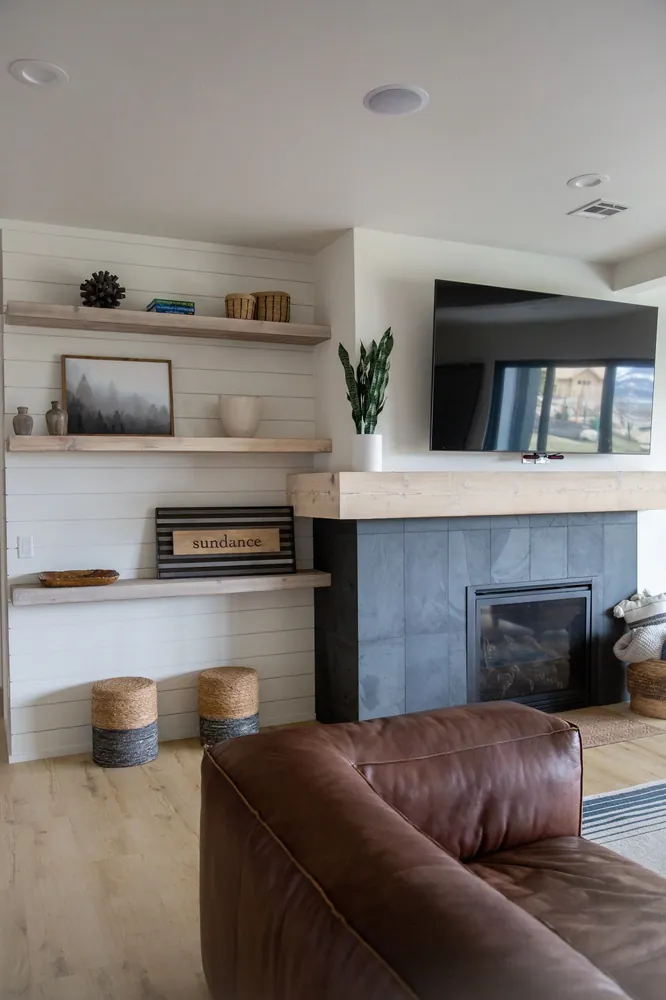 Fireplace with a floating wood mantel and shelves