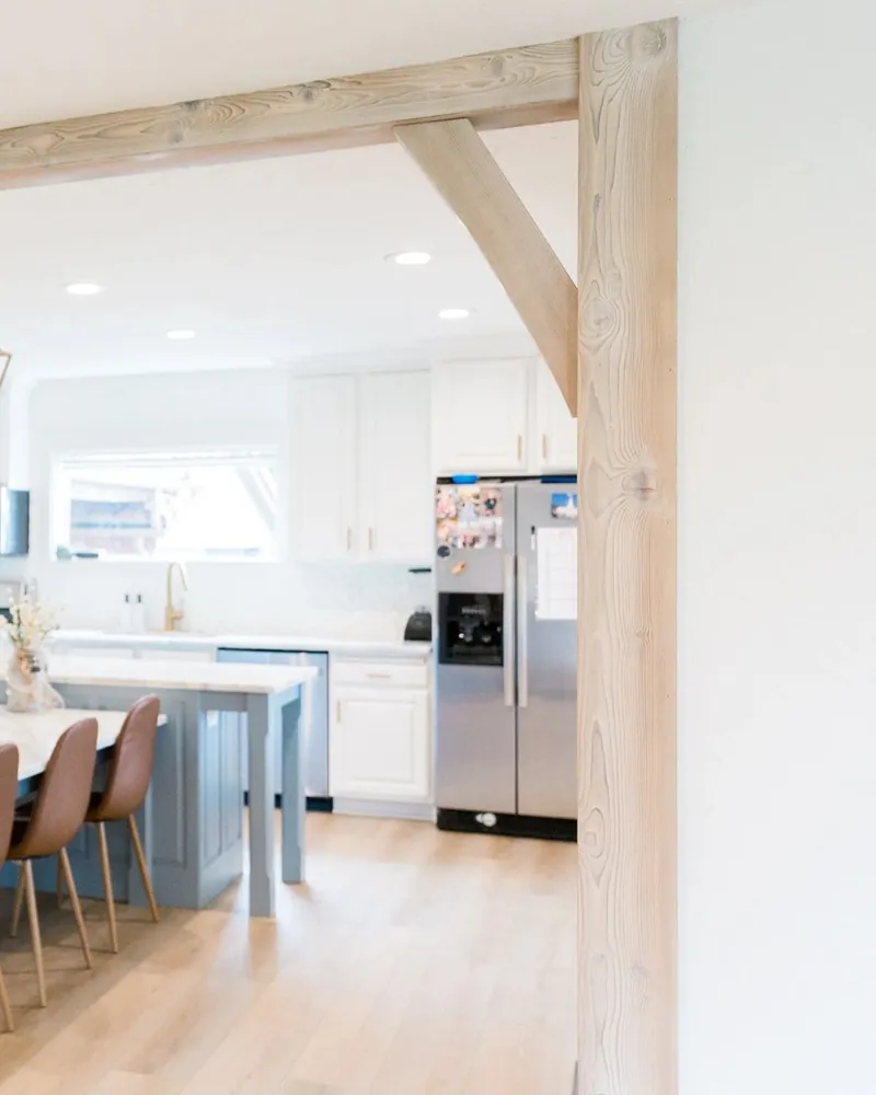 Wood-wrapped doorway opening into a kitchen